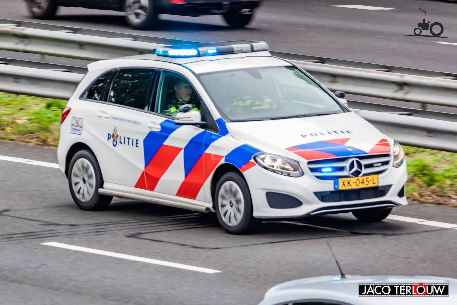 Politie (Den Haag) × op de foto met een Mercedes-Benz B-klasse, opgebouwd voor personenvervoer.